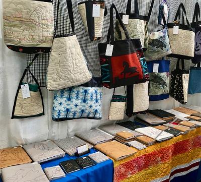 Gallery 10 - books and bags and quilts at a show booth